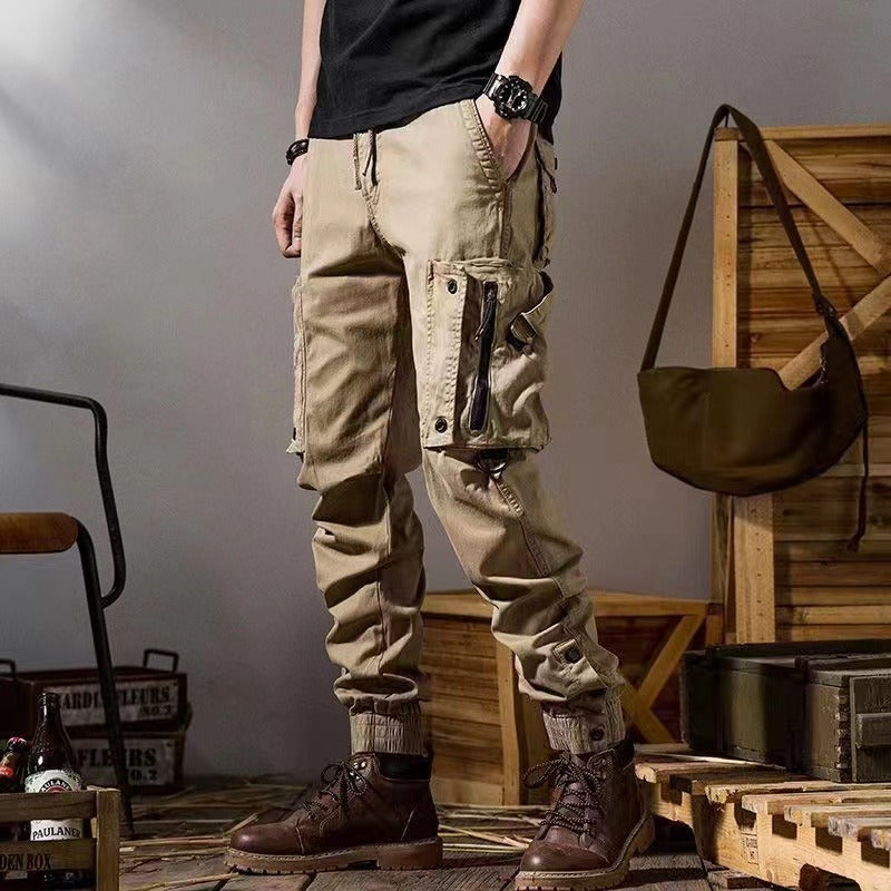 Pantaloni cargo uomo beige, stile militare, con tasche multiple, abbinati a stivali marroni. Moda casual maschile, abbigliamento outdoor.