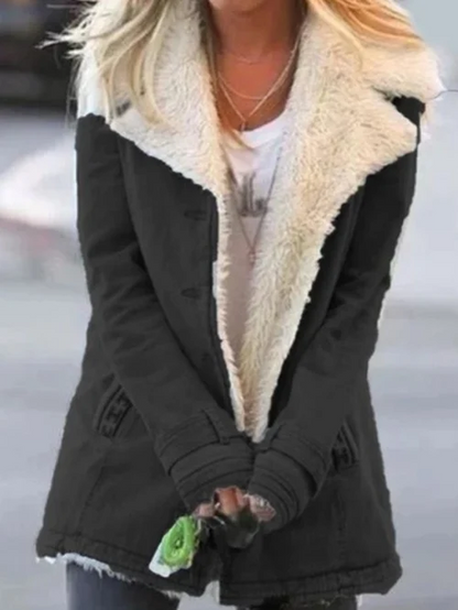 Giacca invernale nera con fodera in pelliccia bianca, indossata da una donna bionda. Moda femminile, abbigliamento caldo, stile casual.