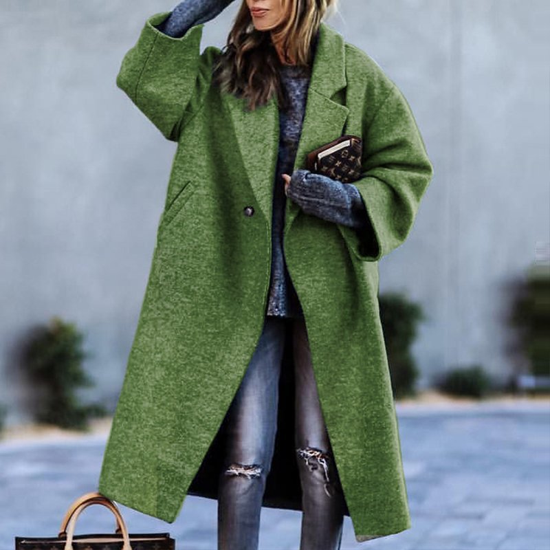 Donna con cappotto verde oversize, jeans strappati e maglione grigio, tiene una borsa marrone. Moda invernale, stile casual chic.