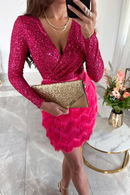 Donna in abito rosa brillante con paillettes, tiene una pochette dorata. Look elegante e glamour, perfetto per eventi serali o feste.