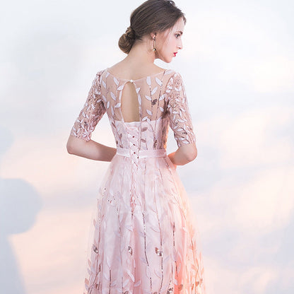 Donna in abito da sera rosa con dettagli floreali e trasparenze, vista posteriore. Moda elegante, abbigliamento femminile, tendenze 2023.