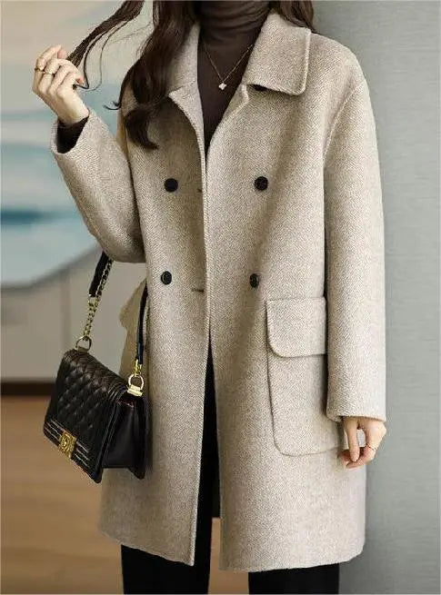 Cappotto beige elegante da donna, doppio petto, con borsa nera a tracolla. Moda autunnale, abbigliamento casual chic.