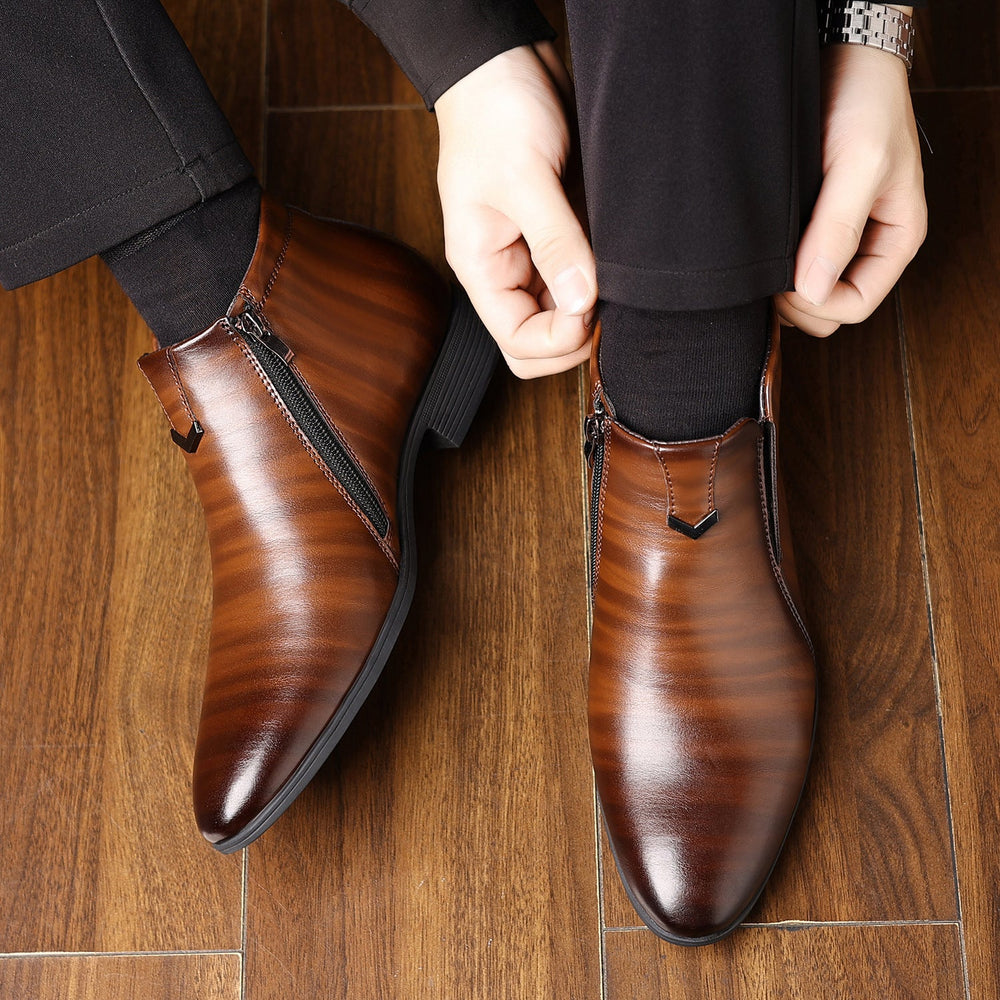 Scarpe eleganti in pelle marrone con cerniera laterale, indossate su pavimento in legno. Calzature uomo moda, stile classico e raffinato.
