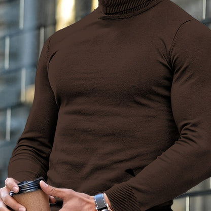 Uomo in maglione marrone a collo alto tiene una tazza di caffè, sfondo urbano sfocato. Moda autunnale, stile casual, accessori eleganti.