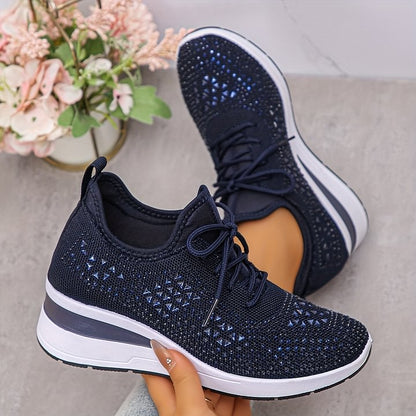 Scarpe da ginnastica nere con dettagli blu, suola bianca, su sfondo grigio. Design moderno e traspirante, perfette per sport e tempo libero.