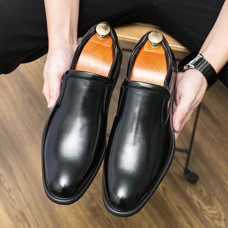 Scarpe eleganti uomo in pelle nera lucida con tendiscarpe in legno, su pavimento in legno. Scarpe formali, moda maschile, calzature di lusso.