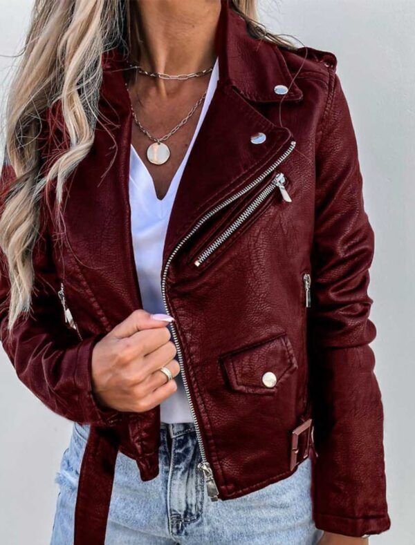Giacca in pelle bordeaux da donna, stile motociclista, con zip argentate e dettagli metallici, indossata su maglietta bianca e jeans chiari.