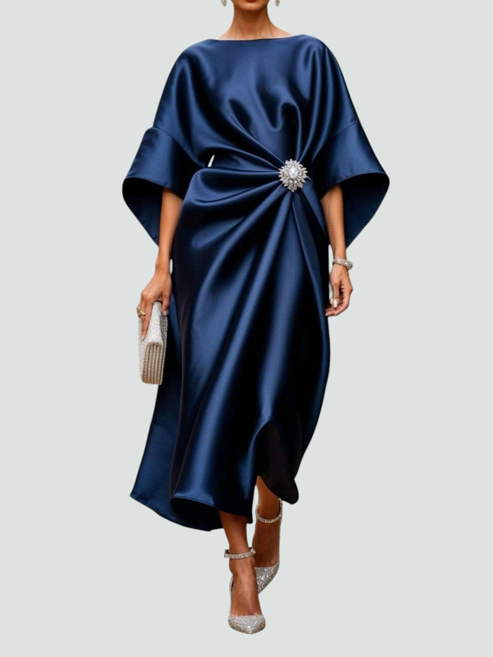 Abito da sera blu scuro in raso con spilla decorativa, maniche ampie, borsa a mano scintillante e scarpe eleganti, moda donna elegante.