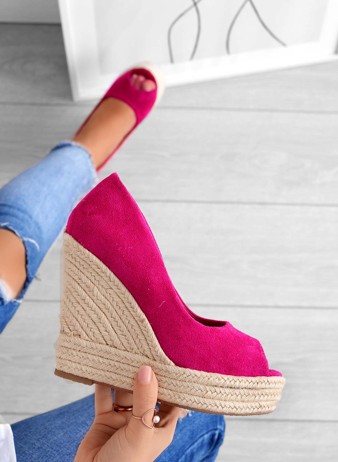Scarpa con zeppa fucsia in tessuto, suola in corda intrecciata, indossata con jeans strappati. Calzature estive moda donna, stile casual chic.