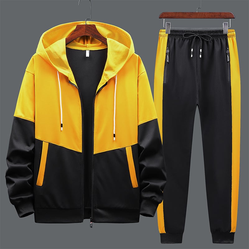 Tuta sportiva gialla e nera, composta da felpa con cappuccio e pantaloni con tasche, ideale per allenamento e tempo libero.