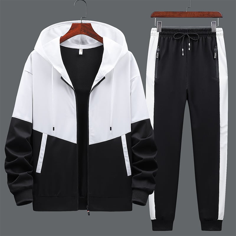 Tuta sportiva uomo bianca e nera, giacca con cappuccio e pantaloni con tasche, design moderno, abbigliamento casual, moda fitness.