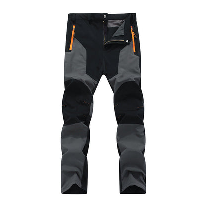 Pantaloni trekking uomo, neri e grigi, con cerniere arancioni. Design resistente, ideale per escursioni e attività outdoor. Tessuto impermeabile.