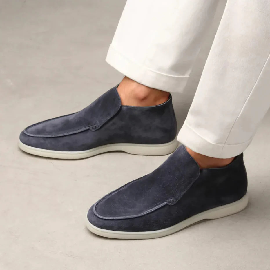 Scarpe uomo in pelle scamosciata blu, design elegante, indossate con pantaloni bianchi. Calzature moda maschile, stile casual chic.
