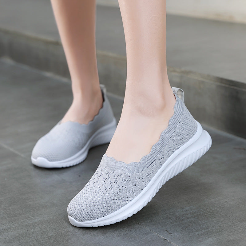 Scarpe da ginnastica grigie da donna, design slip-on, suola bianca antiscivolo, tessuto traspirante, ideali per camminata e attività sportive.