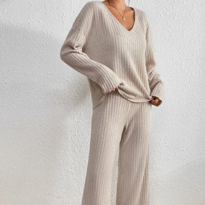 Donna con maglione e pantaloni beige a coste, stile casual chic, su sfondo bianco. Abbigliamento autunnale, moda femminile elegante e confortevole.