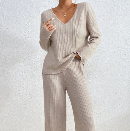 Donna in abbigliamento coordinato beige a coste, maglione e pantaloni, moda autunnale, stile casual chic, sfondo bianco minimalista.