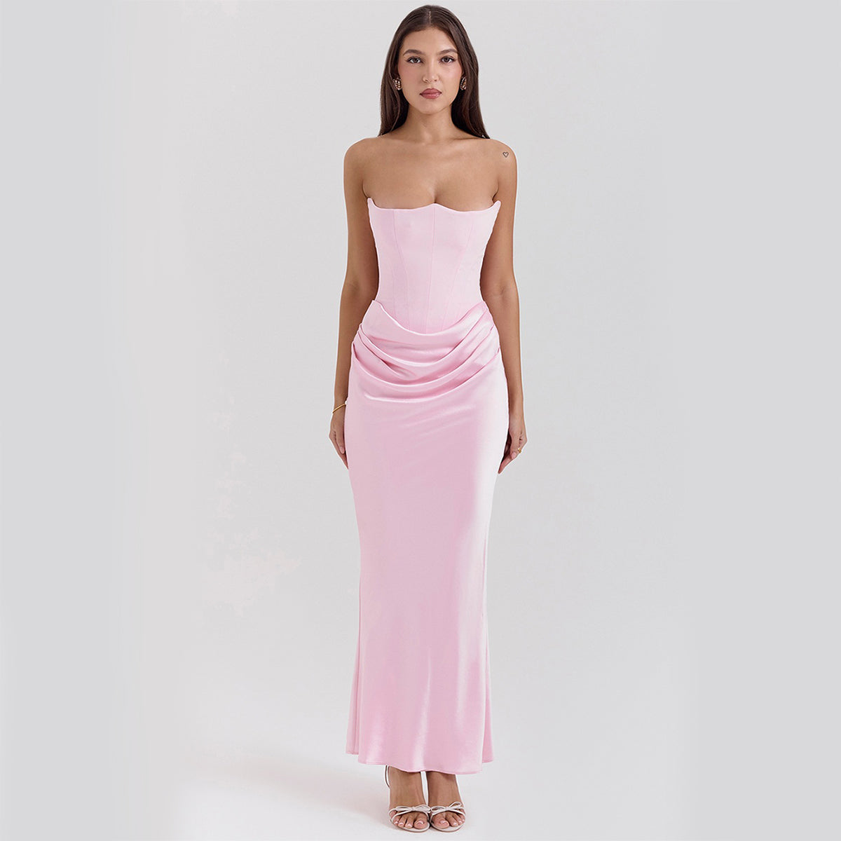Donna in abito lungo rosa senza spalline, elegante e aderente, con drappeggio in vita. Moda femminile, abbigliamento da sera, stile sofisticato.