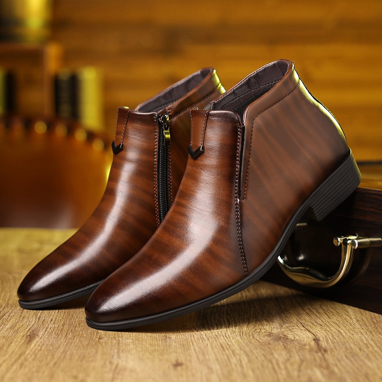 Stivaletti eleganti in pelle marrone con cerniera laterale su sfondo di legno. Scarpe uomo moda autunno, design raffinato e moderno.