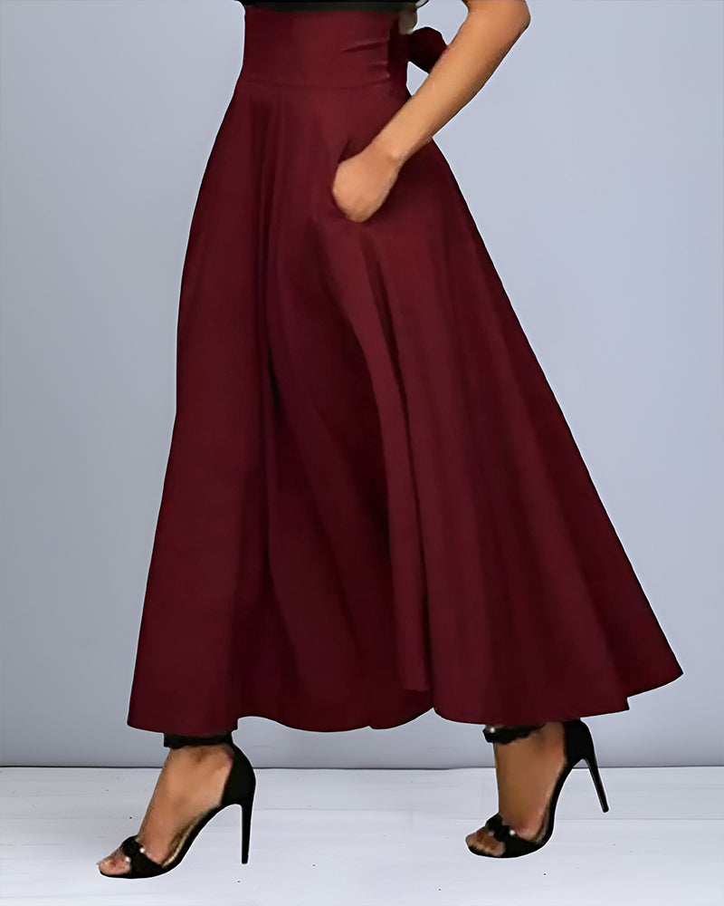 Pantaloni palazzo bordeaux eleganti, vita alta, con tasche, indossati con tacchi neri. Moda donna, abbigliamento chic, stile sofisticato.