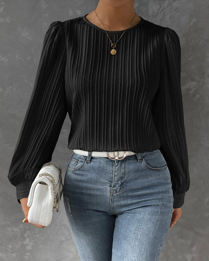 Blusa primaveral de mujer con cuello redondo, mangas largas abullonadas y corte holgado.