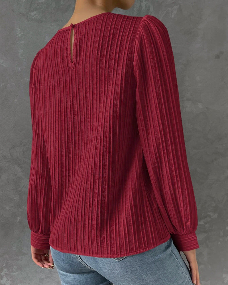 Blusa primaveral de mujer con cuello redondo, mangas largas abullonadas y corte holgado.