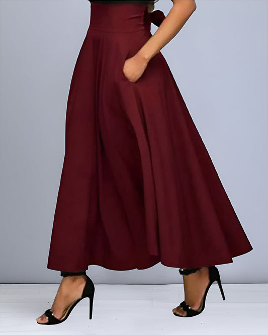 Pantaloni palazzo bordeaux eleganti, vita alta, con tasche, indossati con tacchi neri. Moda donna, abbigliamento chic, stile sofisticato.