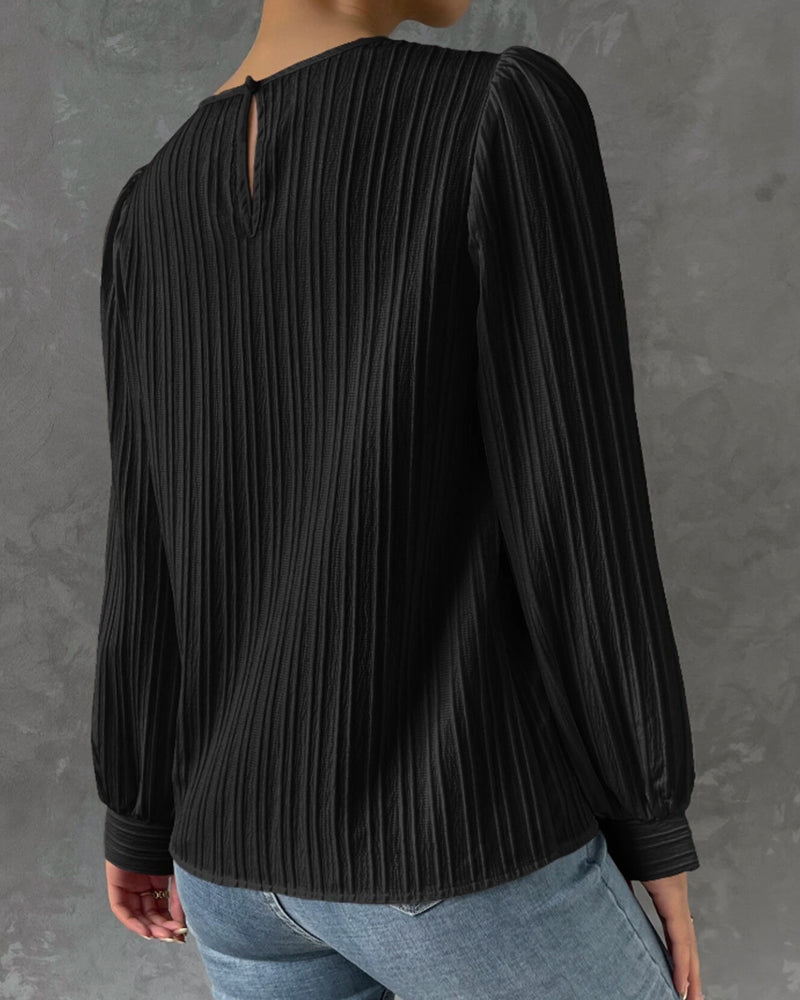 Blusa primaveral de mujer con cuello redondo, mangas largas abullonadas y corte holgado.
