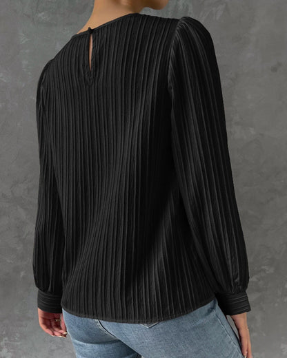 Blusa primaveral de mujer con cuello redondo, mangas largas abullonadas y corte holgado.