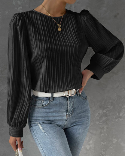 Blusa primaveral de mujer con cuello redondo, mangas largas abullonadas y corte holgado.