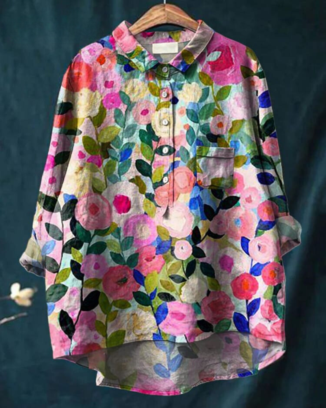 Camicia floreale colorata da donna su gruccia, con motivi di fiori e foglie vivaci. Moda casual, tessuto leggero, ideale per primavera ed estate.