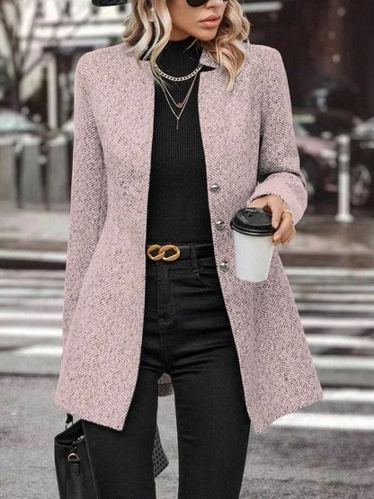 Donna con cappotto rosa elegante, maglione nero e pantaloni scuri, tiene un caffè da asporto. Moda autunnale, stile urbano chic.