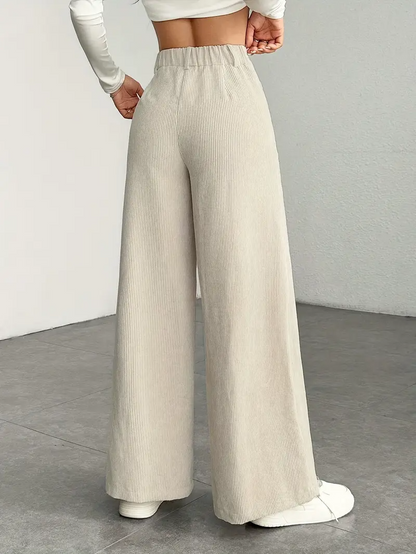 Pantaloni a vita alta beige in velluto a coste, stile casual, indossati da una donna. Perfetti per moda autunnale e look eleganti.