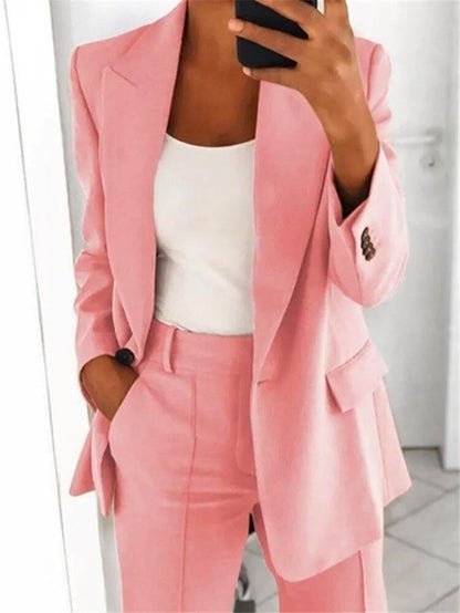Completo donna elegante rosa, giacca e pantaloni, abbinato a top bianco. Moda femminile, abbigliamento formale, stile moderno.