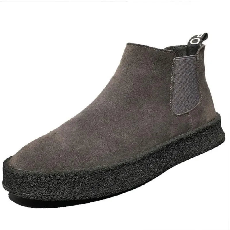 Scarpa Chelsea uomo in pelle scamosciata grigia, suola nera spessa, design moderno, calzatura elegante e casual, moda autunno inverno.