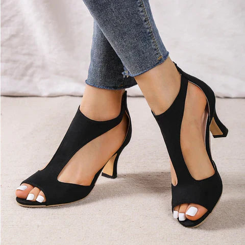 Scarpe col tacco aperte nere eleganti, indossate con jeans aderenti. Design moderno e chic, perfette per moda donna e outfit serali.
