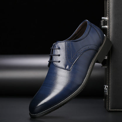 Scarpa elegante da uomo in pelle blu scuro con lacci, design classico e suola nera, posizionata accanto a una valigia nera.