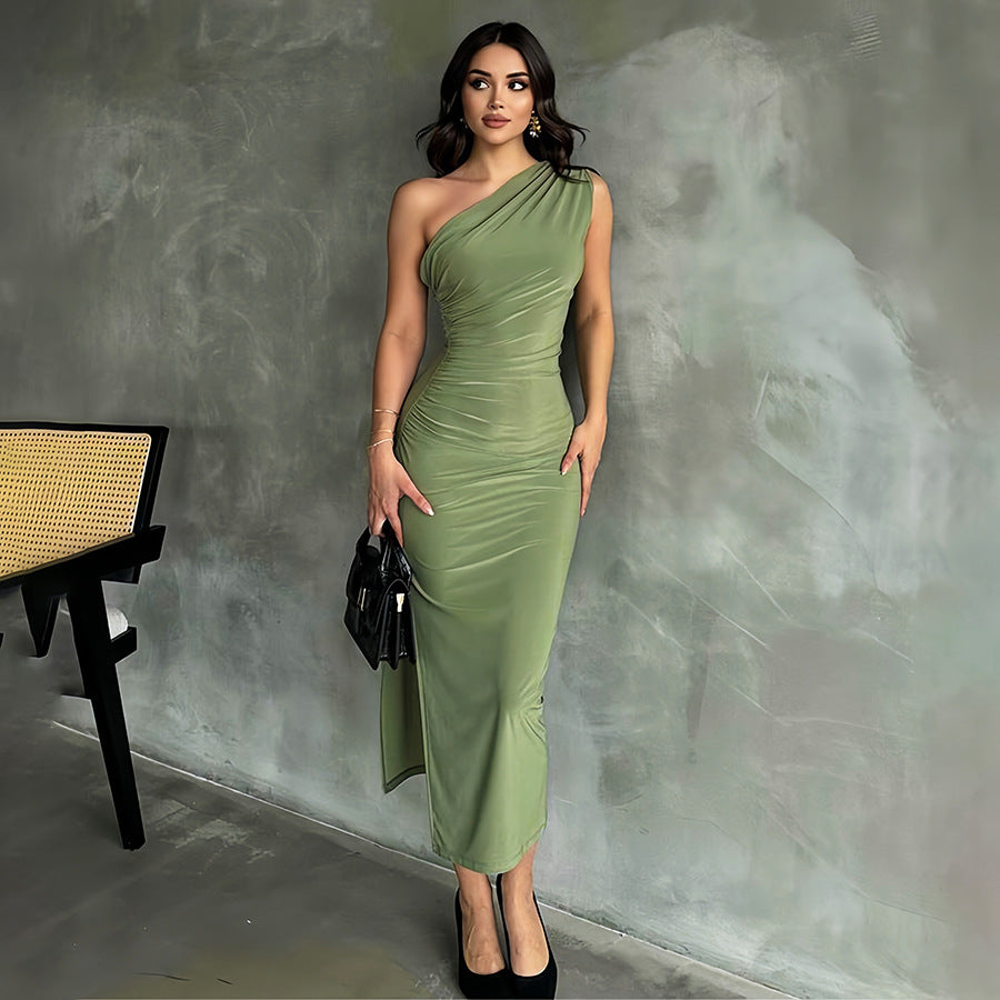 Donna in abito verde elegante, monospalla, posa in interni moderni. Moda femminile, abbigliamento da sera, stile sofisticato.