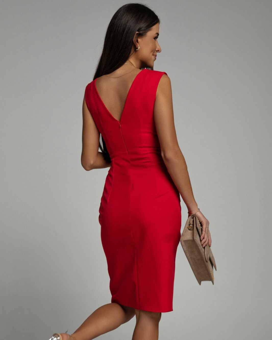 Donna in abito rosso elegante, vista posteriore, con borsa beige. Moda femminile, abbigliamento da sera, stile sofisticato.