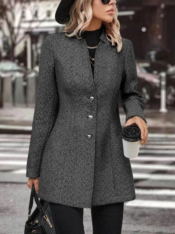 Donna con cappotto grigio elegante, cappello nero e occhiali da sole, tiene caffè da asporto e borsa nera. Moda autunnale urbana.
