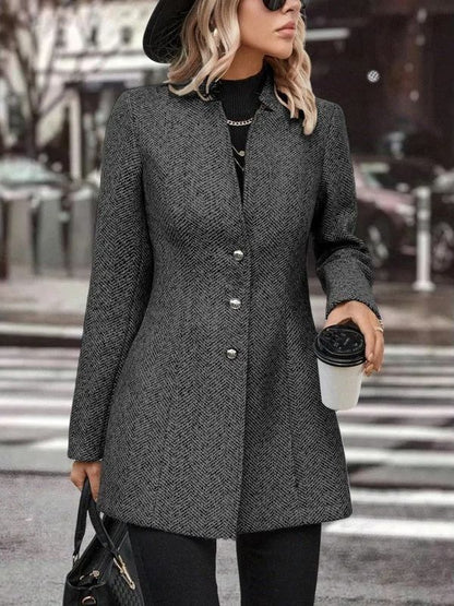 Donna con cappotto grigio elegante, cappello nero e occhiali da sole, tiene caffè da asporto e borsa nera. Moda autunnale urbana.