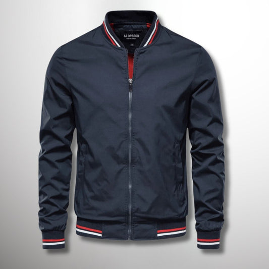 Giacca bomber blu scuro con zip, colletto e polsini a righe rosse e bianche. Moda uomo, abbigliamento casual, stile sportivo.