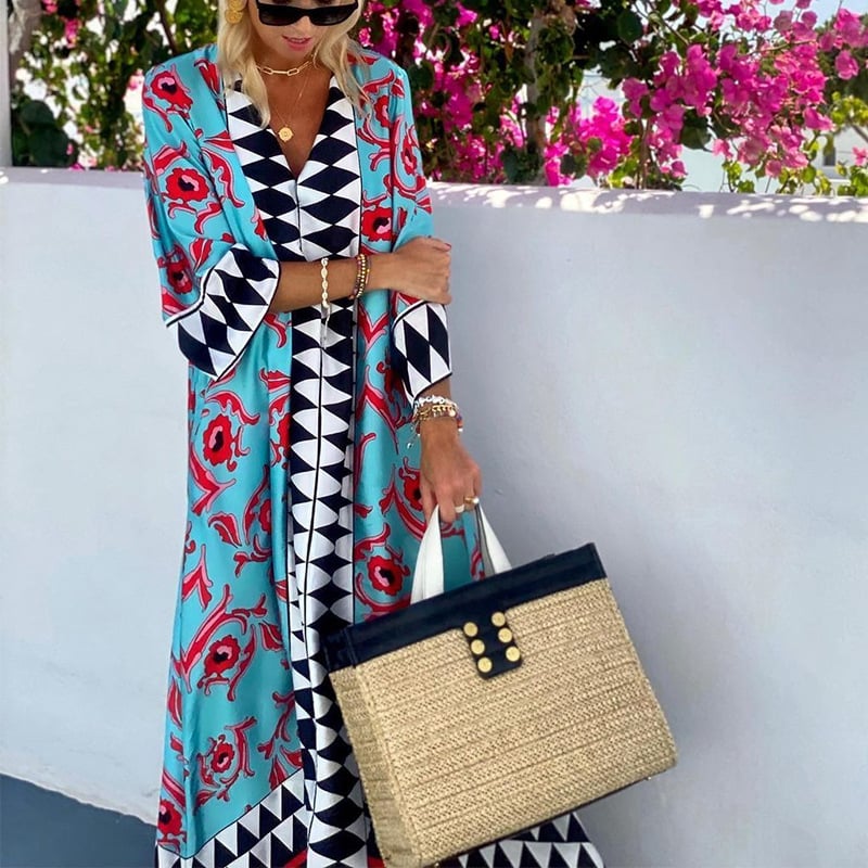 Donna con abito lungo colorato e borsa di paglia, sfondo di fiori rosa. Moda estiva, abbigliamento elegante, accessori di tendenza.