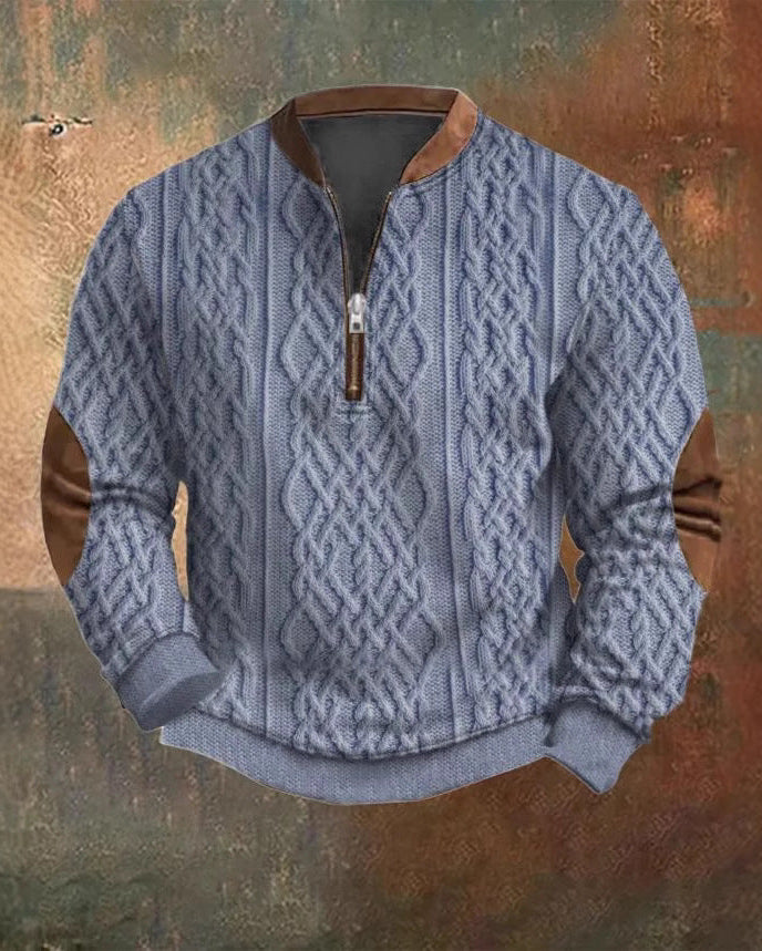Maglione invernale grigio con motivo a trecce, zip frontale e dettagli in pelle marrone su gomiti e collo, su sfondo artistico.