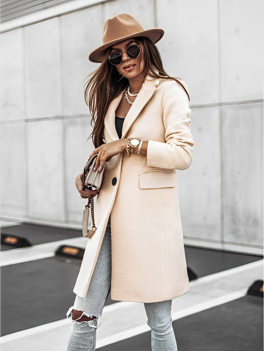 Donna alla moda con cappotto beige, jeans strappati, cappello marrone e occhiali da sole. Look autunnale elegante e casual in città.