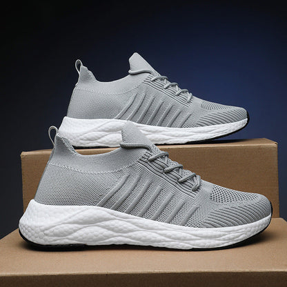 Scarpe da ginnastica grigie su scatole di cartone, design moderno e traspirante, suola bianca ammortizzata. Scarpe sportive leggere e comode.