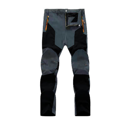 Pantaloni da trekking impermeabili grigi e neri, con rinforzi sulle ginocchia e tasche con cerniera arancione, ideali per escursioni outdoor.