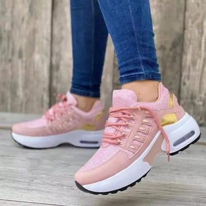 Scarpe da ginnastica rosa con dettagli dorati, suola bianca spessa, indossate con jeans aderenti. Sneakers moda donna, stile casual e sportivo.