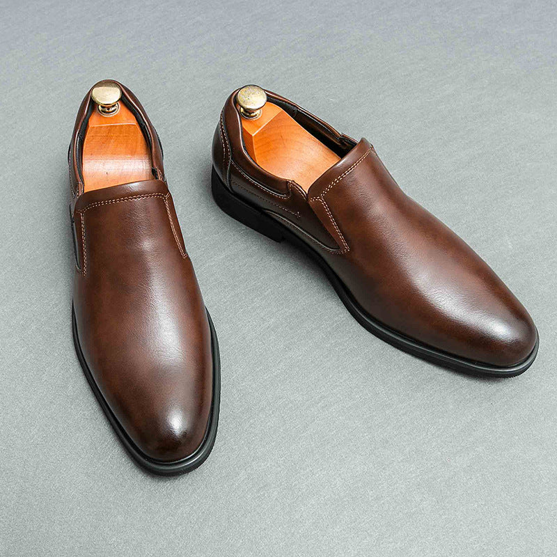 Scarpe eleganti uomo in pelle marrone, modello slip-on, su sfondo grigio. Calzature formali di alta qualità, ideali per ufficio e cerimonie.