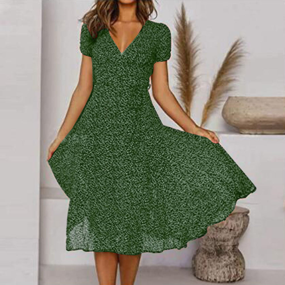 Abito verde a fiori, donna in posa elegante, sfondo neutro con decorazioni naturali. Moda estiva, stile casual chic, tendenze abbigliamento femminile.