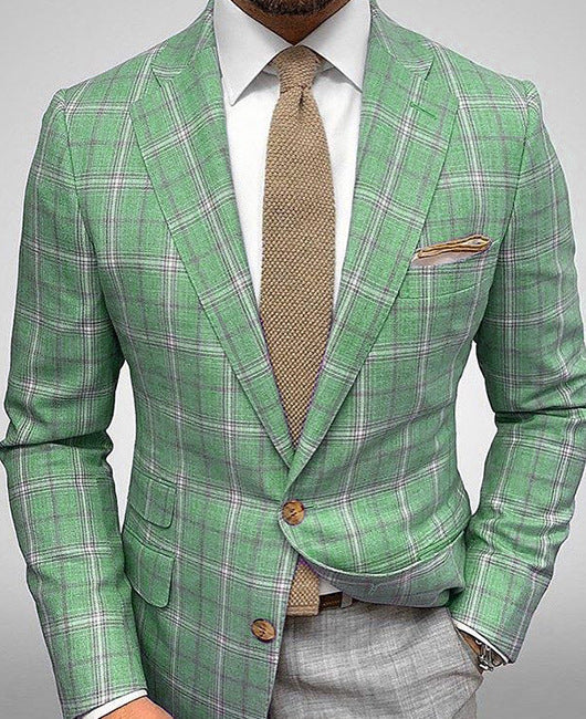 Giacca uomo verde a quadri, elegante e moderna, abbinata a cravatta marrone e pantaloni grigi. Moda maschile, abbigliamento formale.
